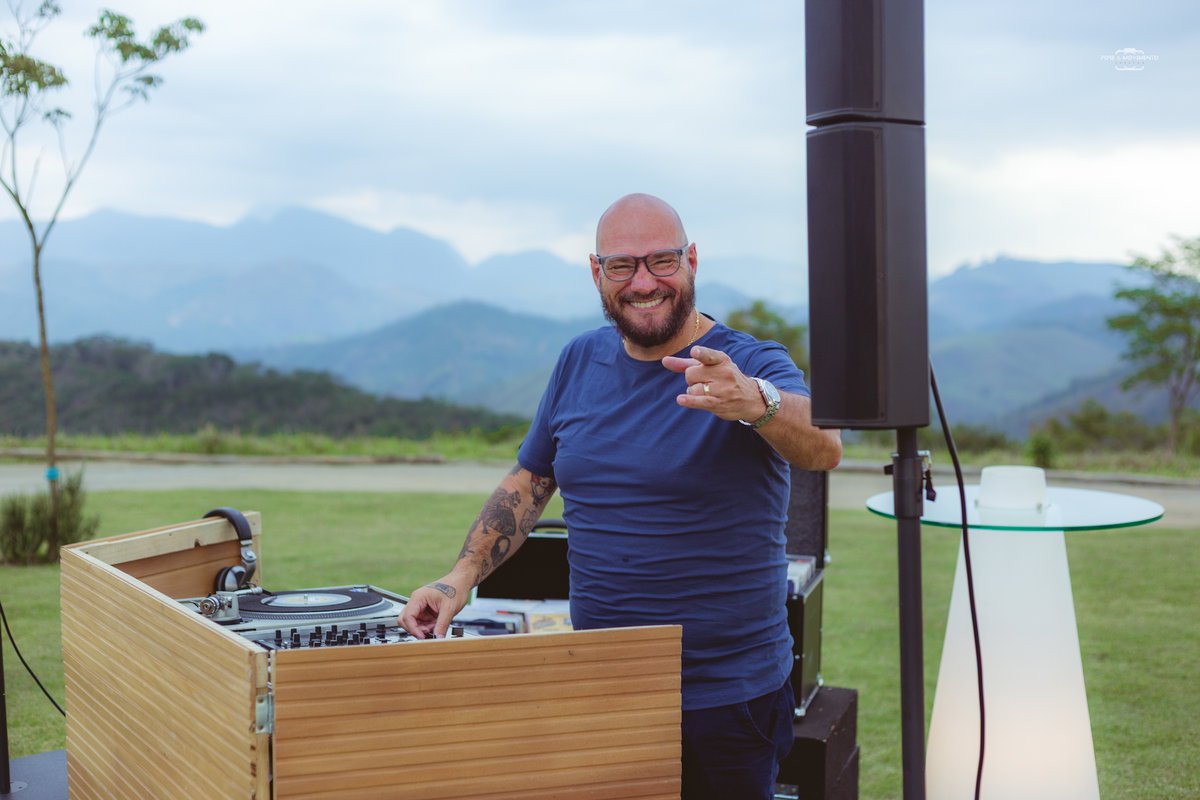 DJ Rafa Justen na cabine com toca-discos, com a serra ao fundo