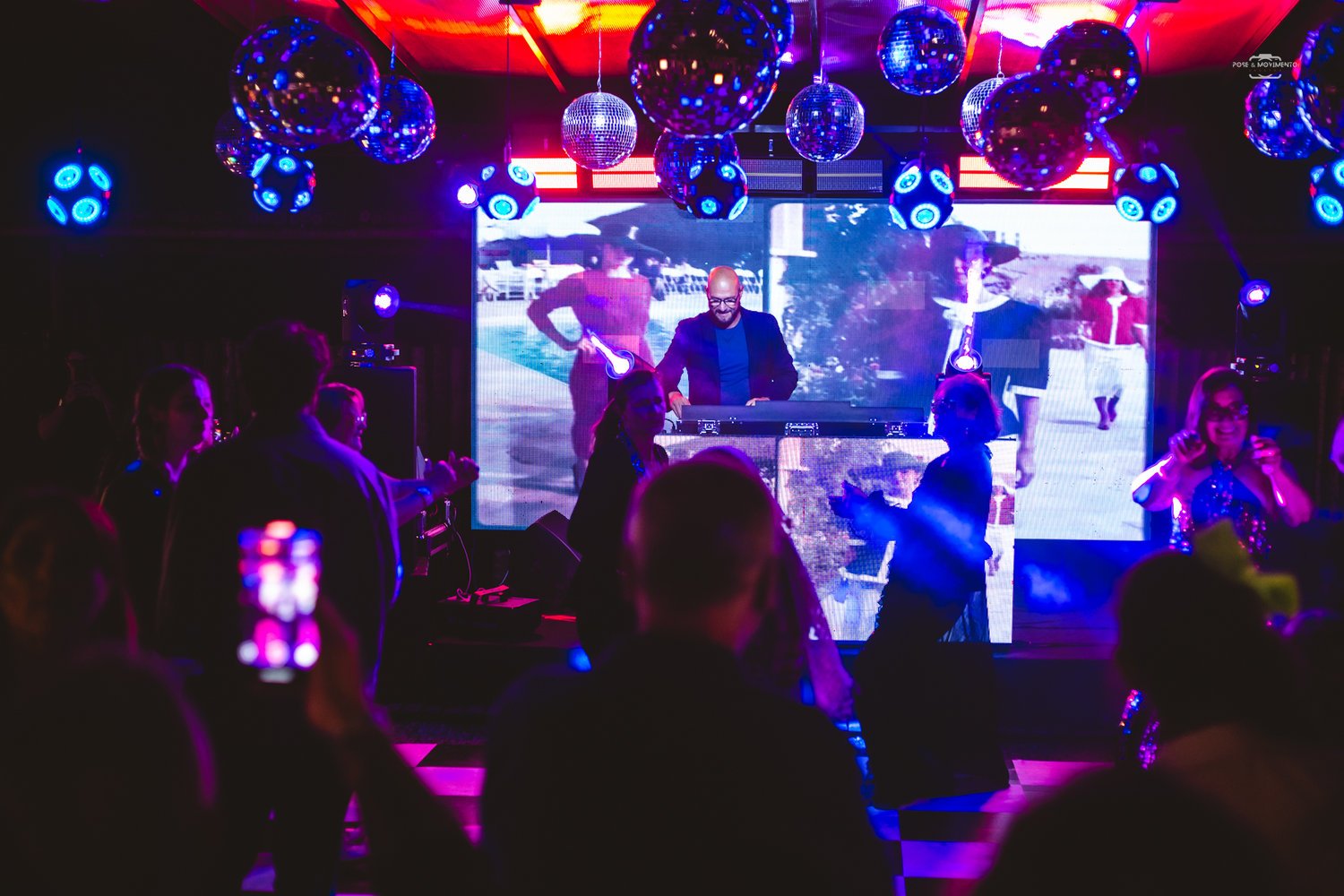 Pista lotada à noite com painel de LED e globos espelhados