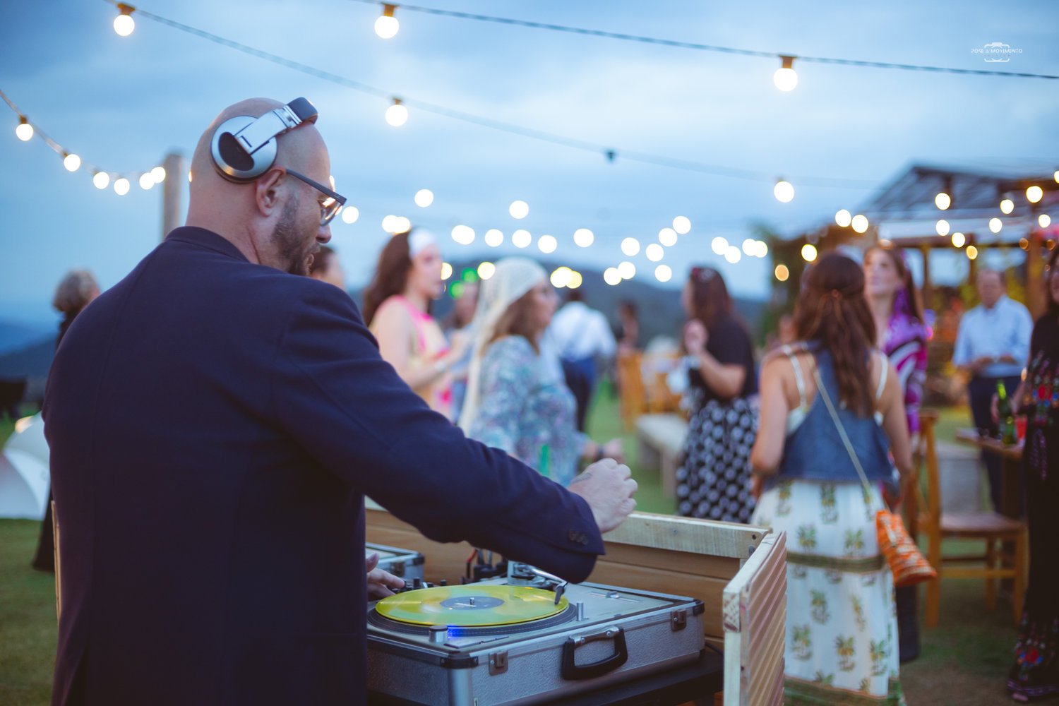 DJ tocando disco de vinil ao ar livre no fim da tarde