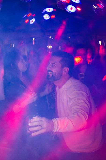Convidado dançando sob a luz rosa e roxa