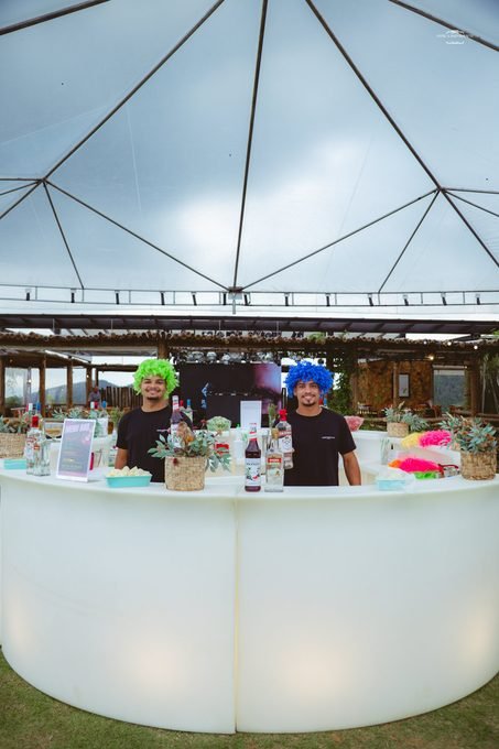 Bar iluminado com bartenders caracterizados