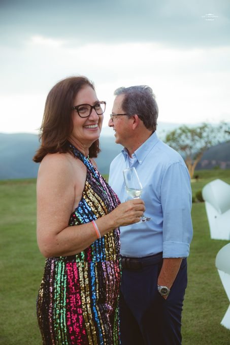 Casal conversando e rindo no gramado ao entardecer