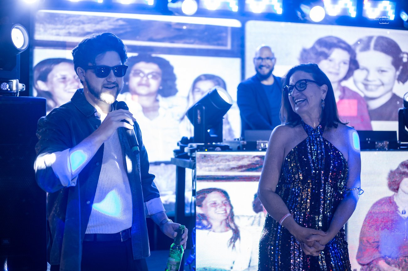 Agradecimento no palco, com fotos antigas de família passando no painel de LED