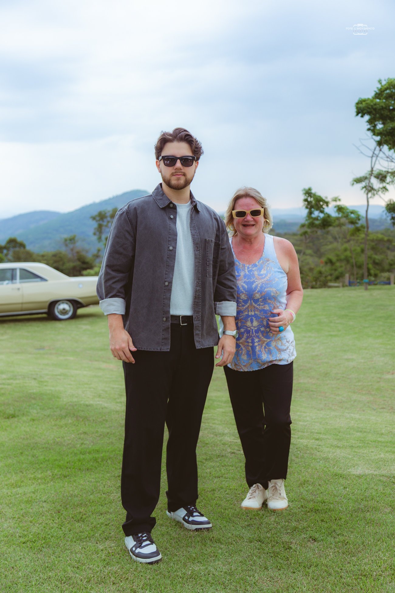 Convidados no gramado do Celeiro Monte Alto, com a serra e um carro clássico ao fundo