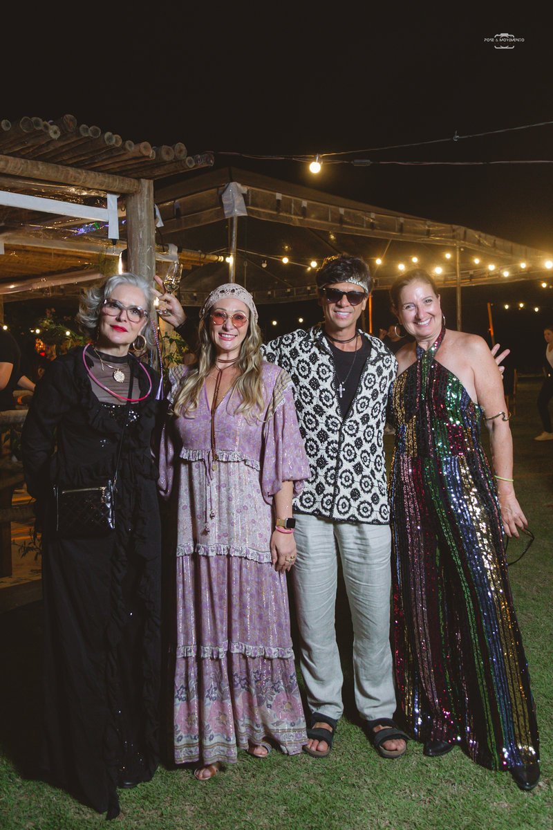 Quatro convidados com vestidos longos e camisa de crochê à noite